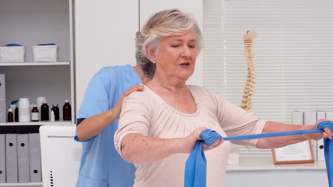 Physiotherapist-examining-elderly-patients-back
