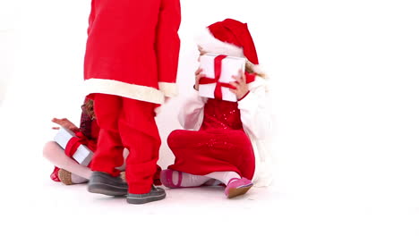 Süße-Festliche-Kinder-Bekommen-Geschenke-Von-Einem-Kleinen-Jungen,-Der-Als-Weihnachtsmann-Verkleidet-Ist