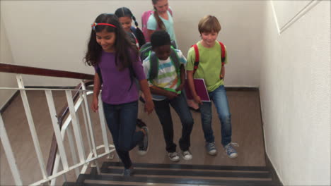 Cute-pupils-smiling-and-walking-up-stairs