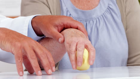 Arzt-Zeigt-Patienten,-Wie-Man-Verletzte-Hand-Trainiert