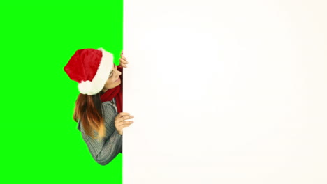 Beauty-brunette-in-santa-hat-pointing-white-poster