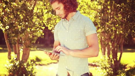 En-Formato-4k-De-Alta-Calidad,-Un-Joven-Usando-Una-Tableta-En-El-Parque.