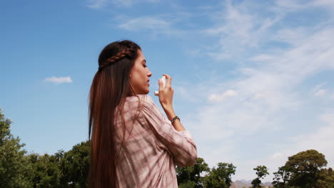 Pretty-brunette-using-her-inhaler-