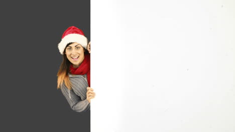 Beauty-brunette-in-santa-hat-showing-white-poster