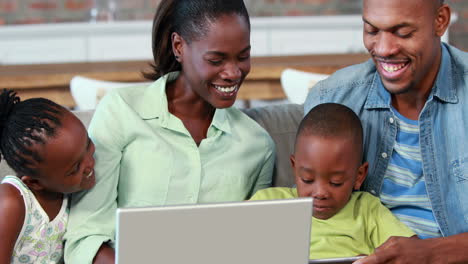 Familia-Feliz-Usando-Una-Computadora-Portátil