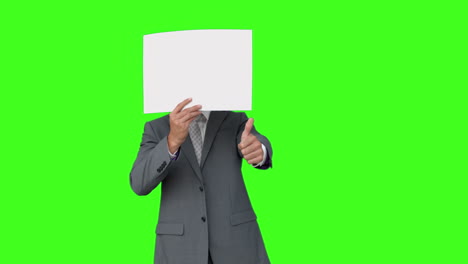 Businessman-standing-with-page-over-face