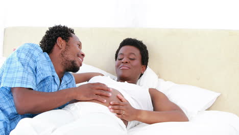 Pregnant-couple-discussing-together-on-the-bed
