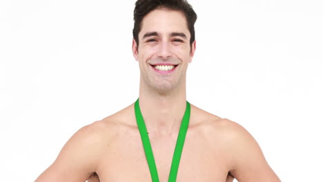 Smiling-shirtless-athlete-with-medal-showing-thumb-up