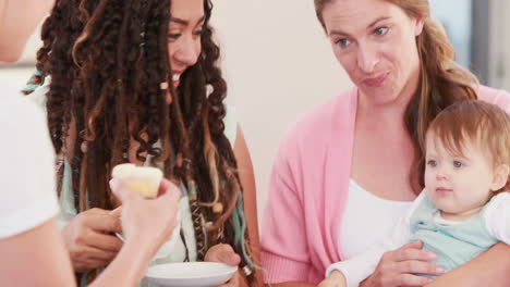 Woman-holding-child-of-lesbian-couple-on-the-couch