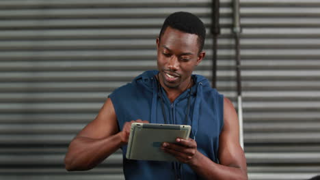 Fit-man-using-tablet-and-smiling-at-the-camera