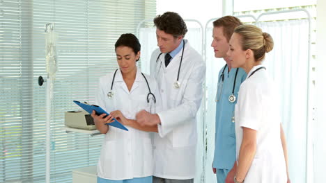 Medical-team-looking-at-clipboard-