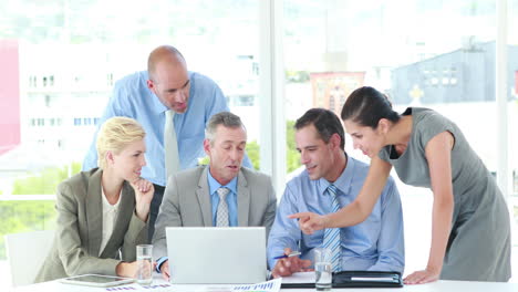 Business-people-looking-at-laptop-computer-during-meeting