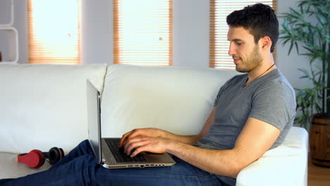 Man-using-his-laptop-on-the-couch