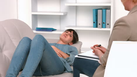 Woman-lying-on-sofa-and-speaking-with-psychologist