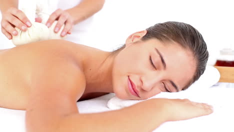 Woman-enjoying-a-herbal-compress-massage