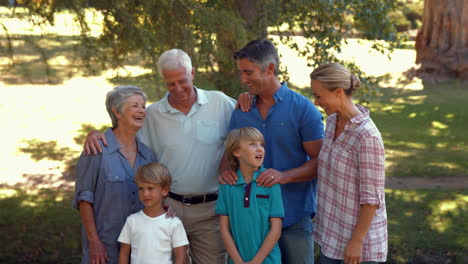 Glückliche-Familie-Lächelt-In-Die-Kamera-Im-Park