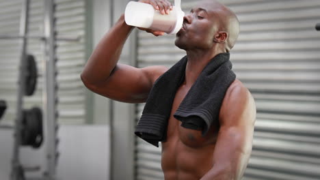 Man-drinking-protein-shake-at-crossfit-gym