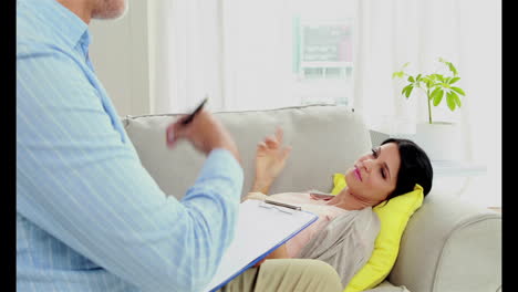 Pregnant-woman-lying-on-sofa-talking-to-therapist