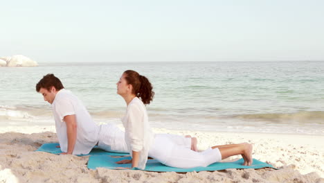 Peaceful-couple-stretching-at-the-beach