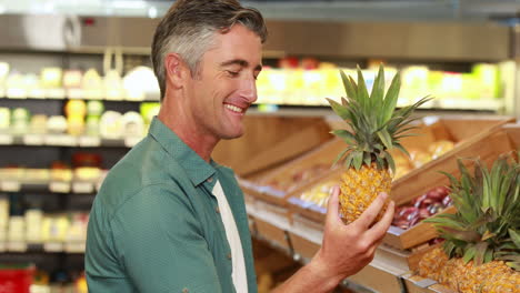 Smiling-man-choosing-pineapple