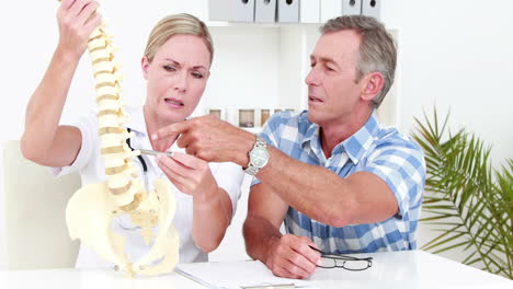 Doctor-explaining-anatomical-spine-to-her-patient-