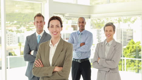 Happy-business-team-smiling-at-camera-with-arms-crossed