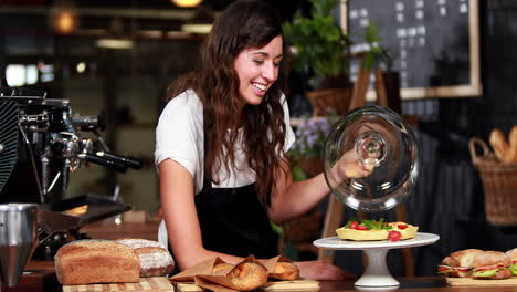 Smiling-waitress-showing-strawberry-pie