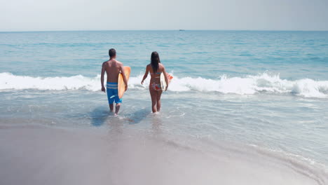 Two-surfer-walking-on-the-sea-with-surfboard-