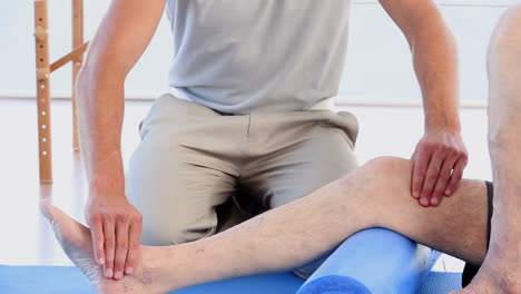 Doctor-massaging-his-patients-knee-and-ankle