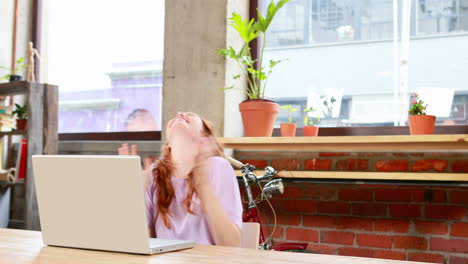 Casual-businesswoman-working-at-her-desk