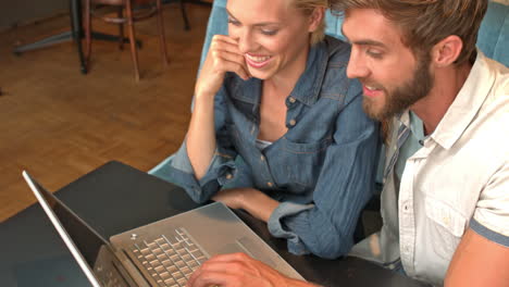 Linda-Pareja-Usando-Una-Computadora-Portátil-En-La-Cafetería