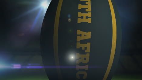 Pelota-De-Rugby-De-Sudáfrica-En-El-Estadio-Con-Luces-Intermitentes-