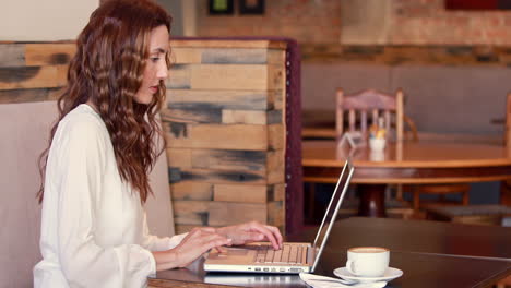 Hübsche-Frau-Trinkt-Kaffee,-Während-Sie-Einen-Laptop-Benutzt-