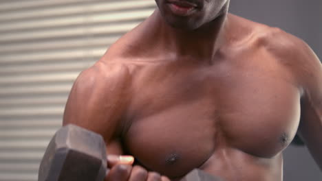 Concentrated-fit-man-holding-dumbbell-