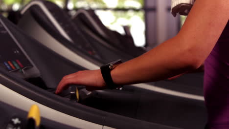Fit-woman-running-on-the-treadmill-with-a-connected-watch