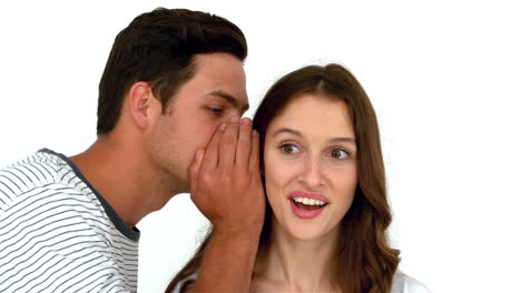 Man-telling-secret-to-surprised-woman