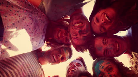 Happy-friends-covered-with-powder-paint-smiling-at-camera