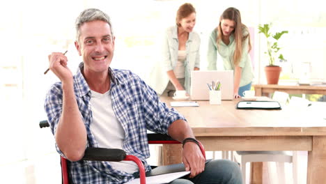 -Casual-businessman-in-wheelchair-working-at-his-desk