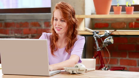 Casual-businesswoman-working-at-her-desk