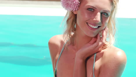 Attractive-blonde-by-the-pool-smiling-at-camera