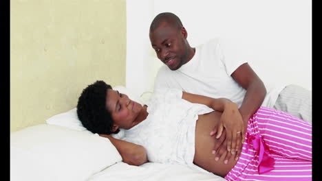 Pregnant-woman-lying-on-the-bed-with-her-husband