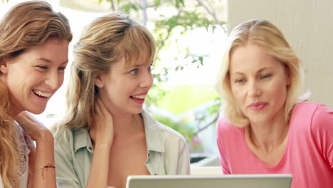 Happy-blonde-friends-looking-at-laptop-computer-