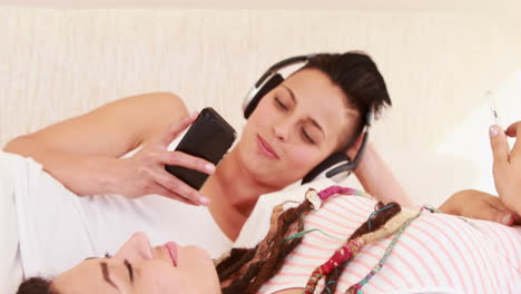 Smiling-lesbian-couple-listening-music-together