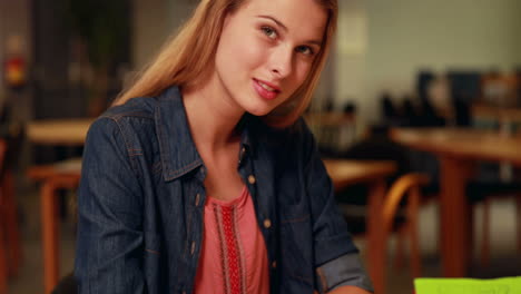 Pretty-student-smiling-at-camera-with-thumb-up