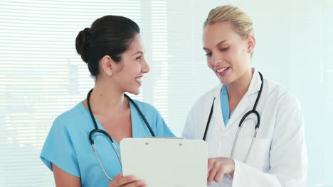 Two-doctors-speaking-together-and-looking-at-clipboard