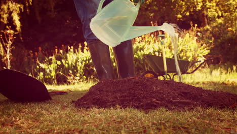 Man-using-watering-can-in-park-