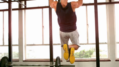 Fit-man-doing-pull-ups-in-fitness-studio