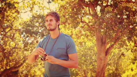 Un-Hombre-Guapo-Usando-Una-Cámara-Fotográfica-Retro-En-El-Parque.