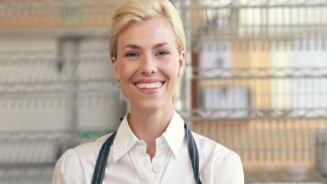 Happy-server-smiling-at-camera-beside-her-cupcakes-