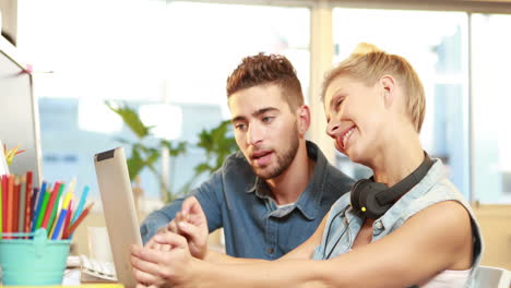 Smiling-casual-businesswoman-explaining-work-to-colleague